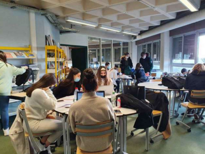 photo du CDI "avant" composé de plusieurs groupes d'élèves qui travaillent dans un espace modulable